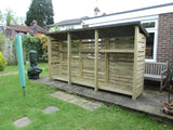 Very large slatted log store with felt roof and shelf